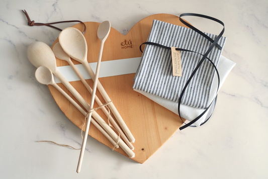 Kitchen gift set with a heart charcuterie board, kitchen towels, and beechwood spoons.